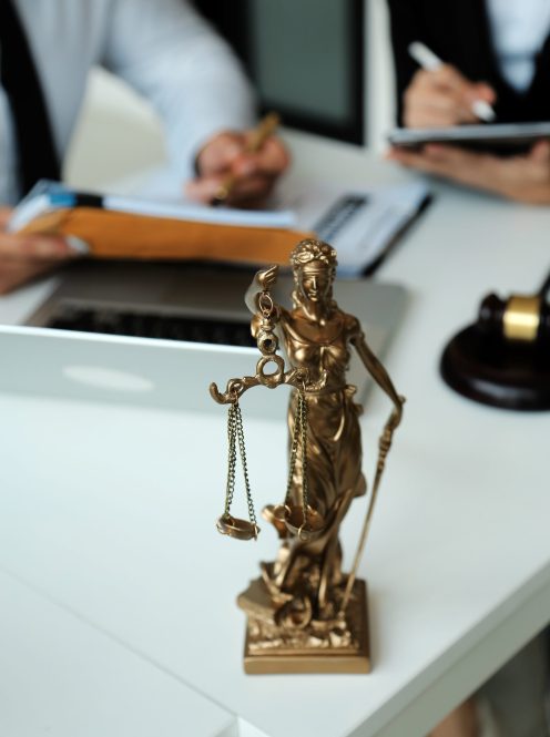 Judge gavel with Justice lawyers having team meeting at law firm in background. Concepts of law.